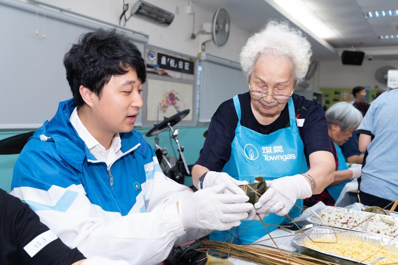  Grandma Chan (right) finds the dumpling-wrapping event interesting and appreciates the patience of the volunteers.